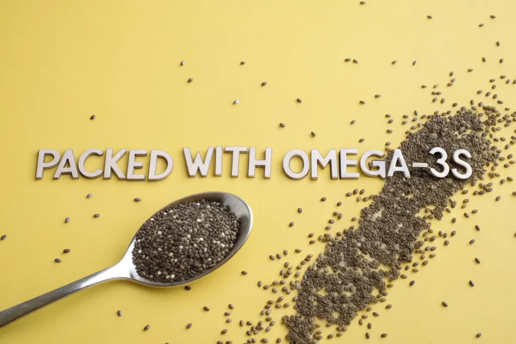 Close-up of chia seeds scattered on a yellow background with a spoon holding a portion